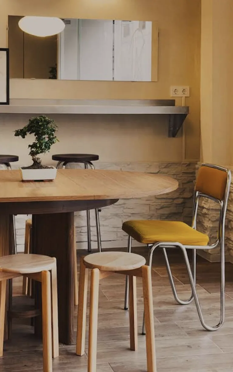 Interior de Gluttoni Cafe con mesa de madera y silla amarilla