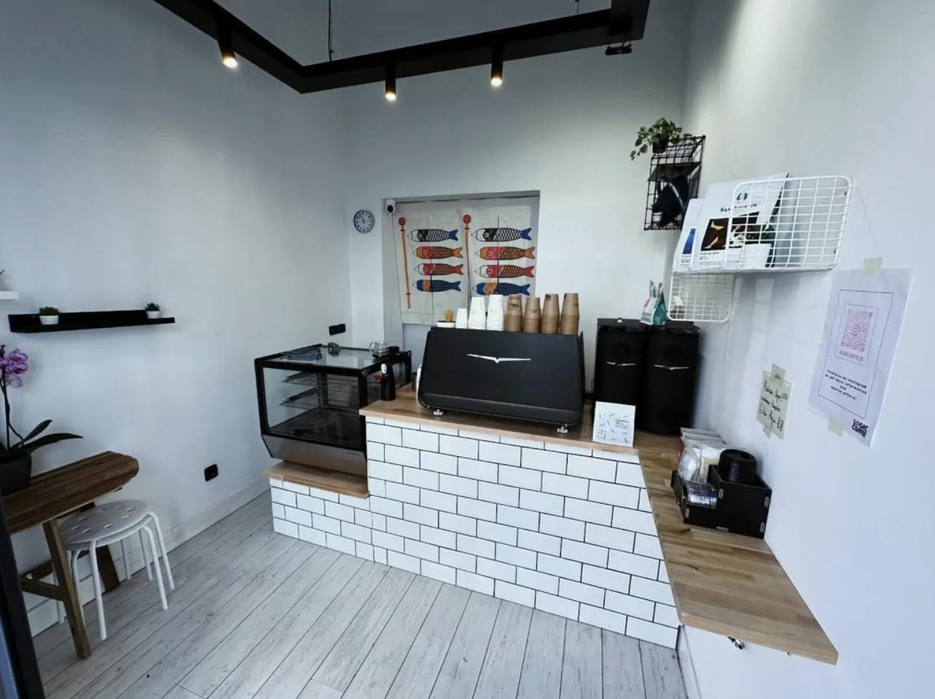 Interior: barra de azulejo blanco, máquina de espresso y koinobori