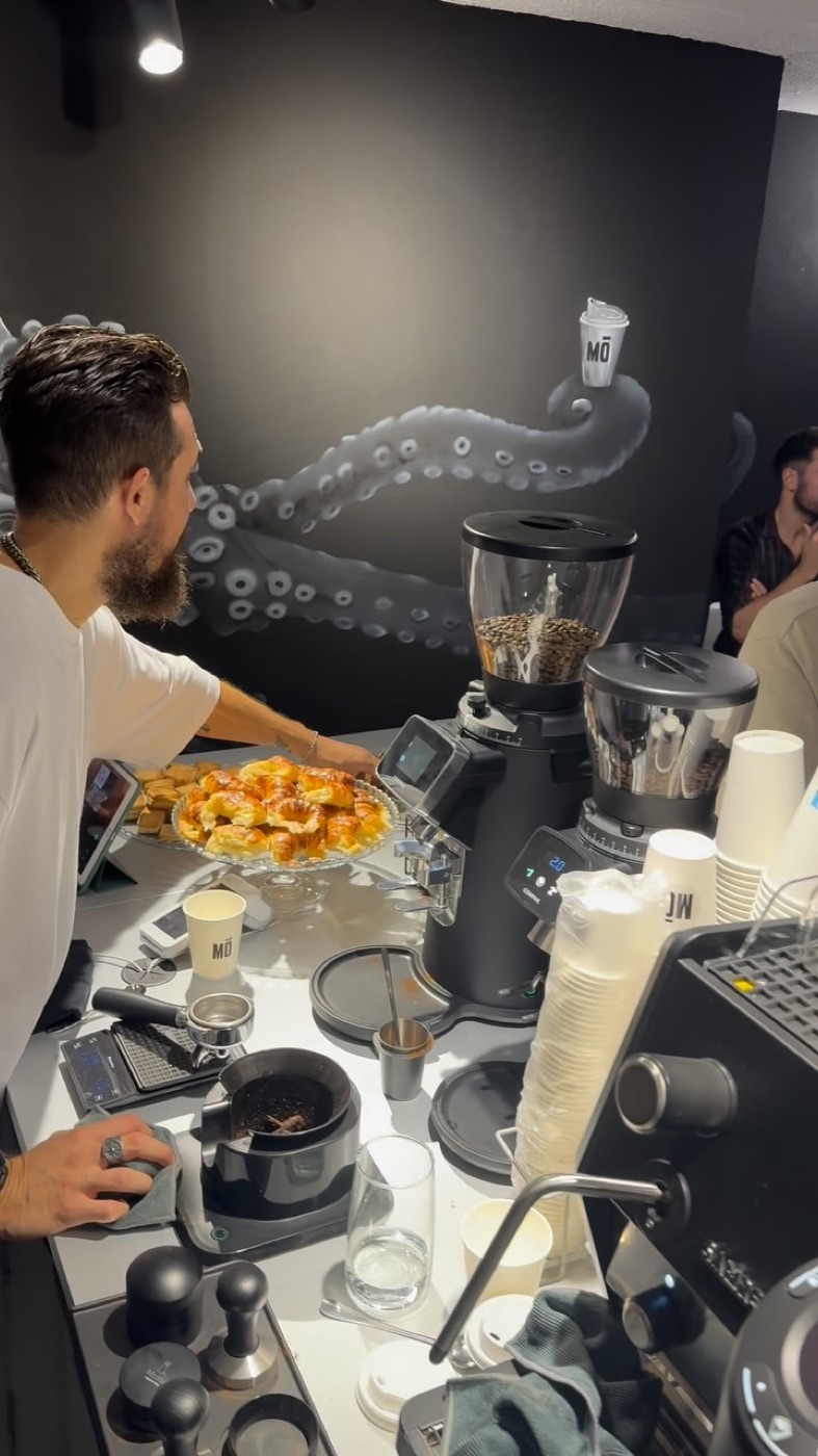 Barista preparando la barra con bandeja de croissants recién hechos