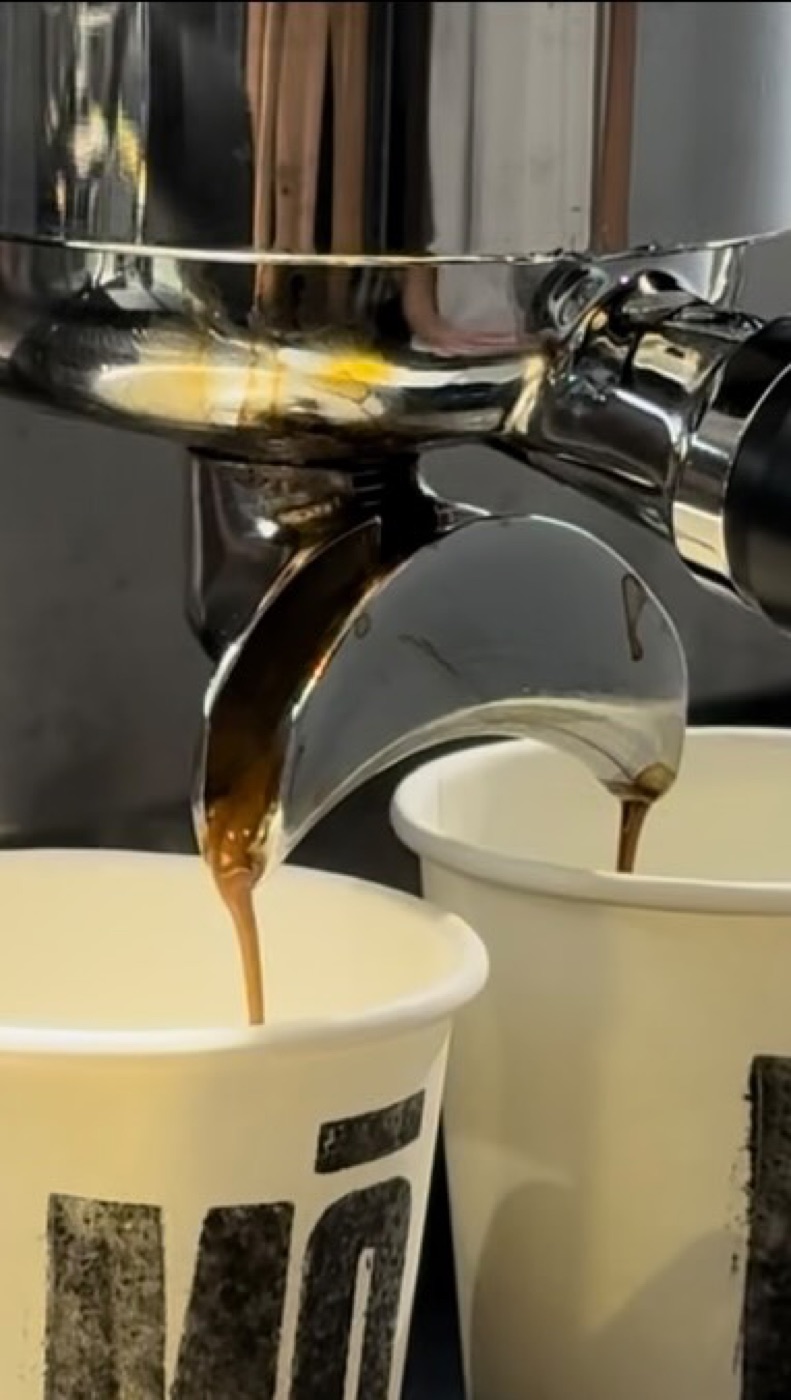 Espresso cayendo en dos vasos con el logo MŌ