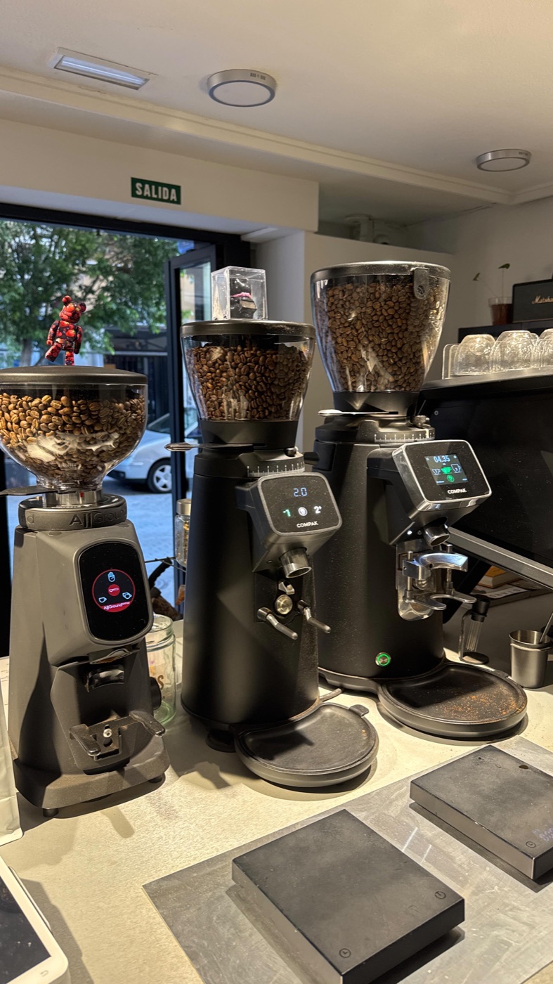 Tres molinos profesionales con tolvas llenas de café en grano