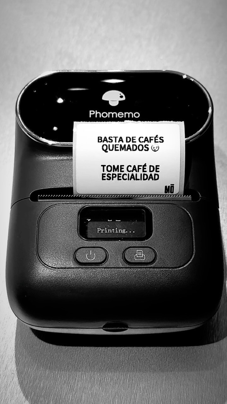 Impresora de tickets imprimiendo el lema: basta de cafés quemados, tome café de especialidad