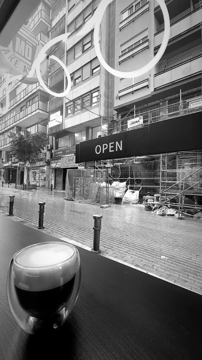 Vista de la calle desde la barra de la ventana de MŌ, con un espresso en primer plano
